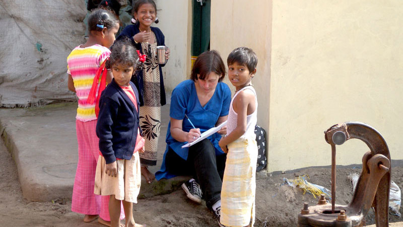 Children gathered around an aid worker
